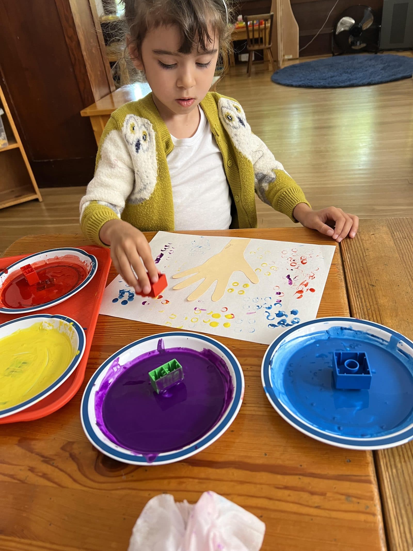 A young student engaged in creative work in the classroom